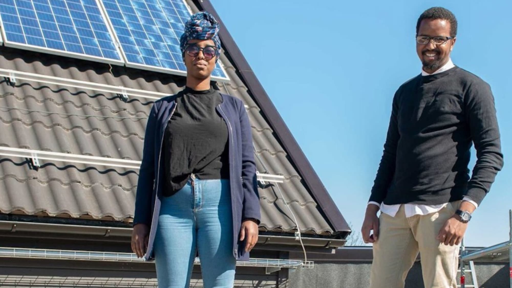 Faisa och Muse står vid ett hus med solceller