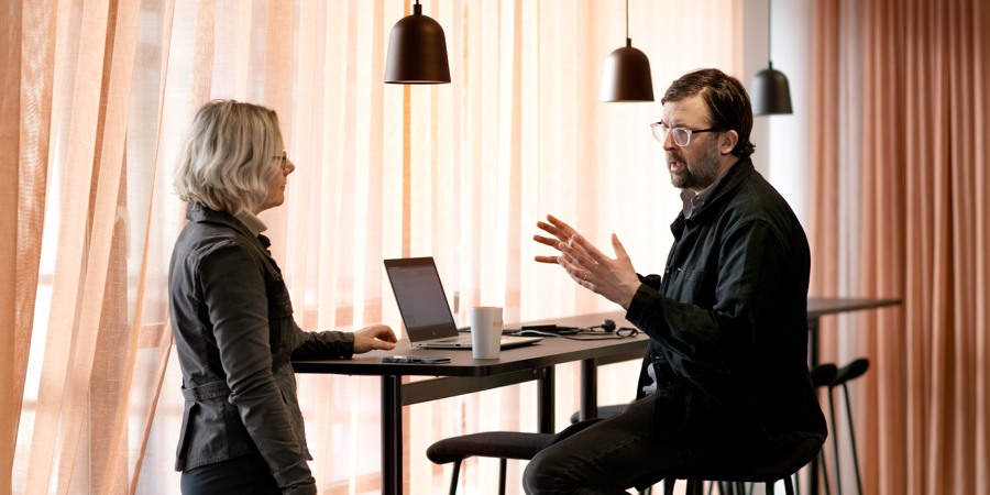 En man och en kvinna sitter vid ett bord och pratar.