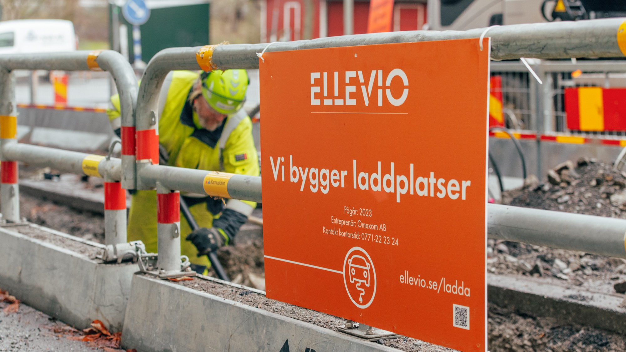 En man i gul jacka arbetar på en byggarbetsplats.