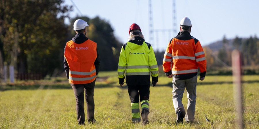 En grupp människor som går över ett grästäckt fält.