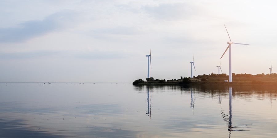 Ett vattendrag med ett gäng väderkvarnar i bakgrunden.