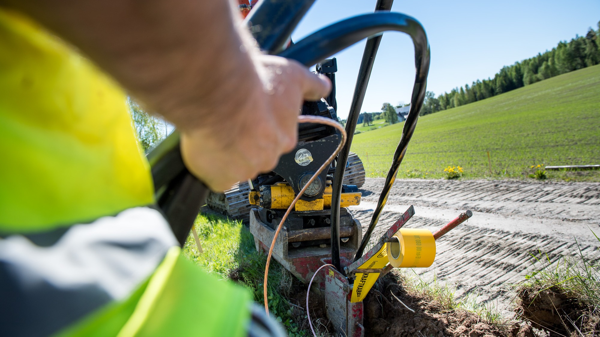 En man använder en maskin för att gräva ett hål i marken.